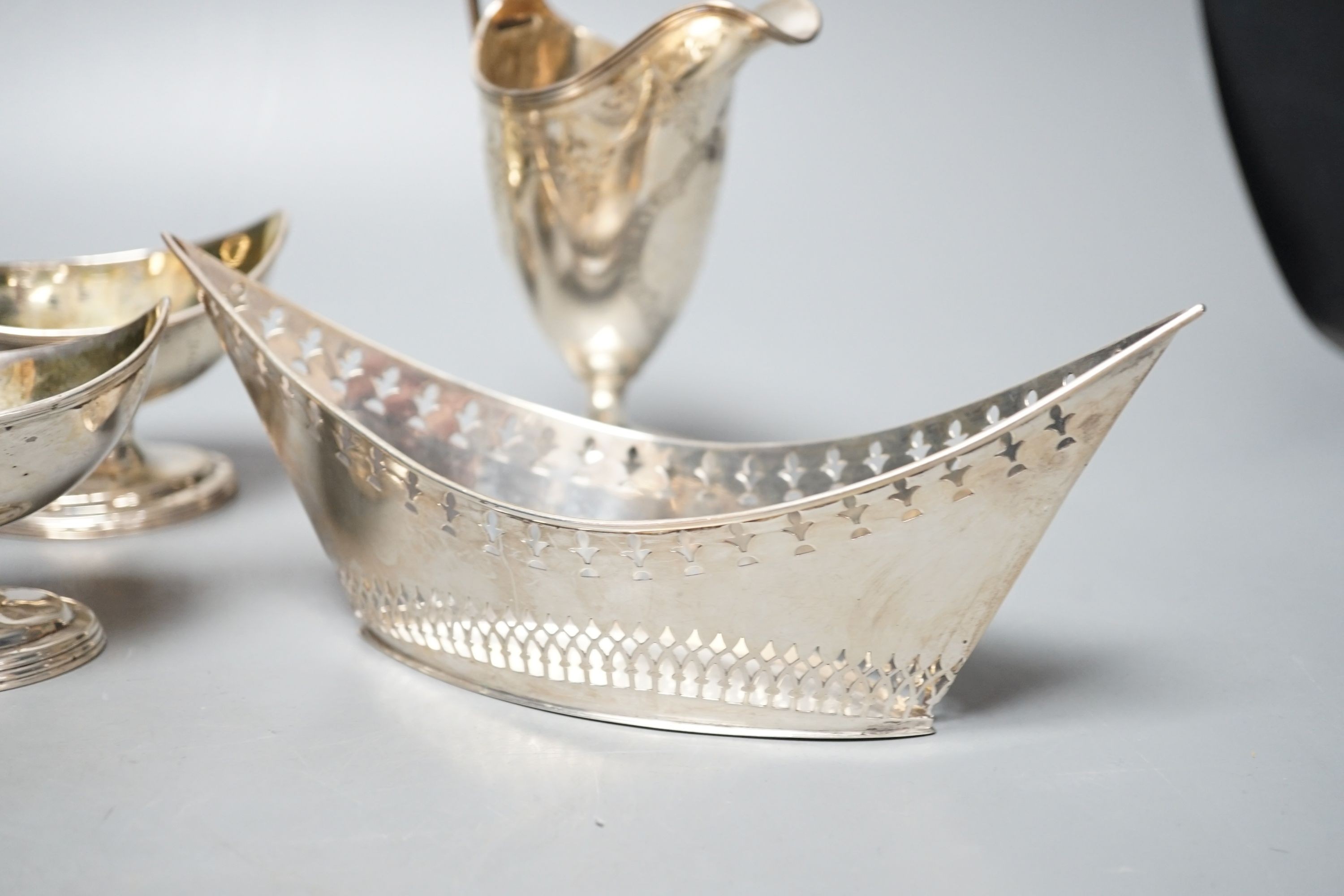 A mixed collection of silver to include a Scottish quaich, a pair of George III boat shaped salts, a George III silver helmet shaped cream jug and a pierced boat-shaped bowl, 17oz.